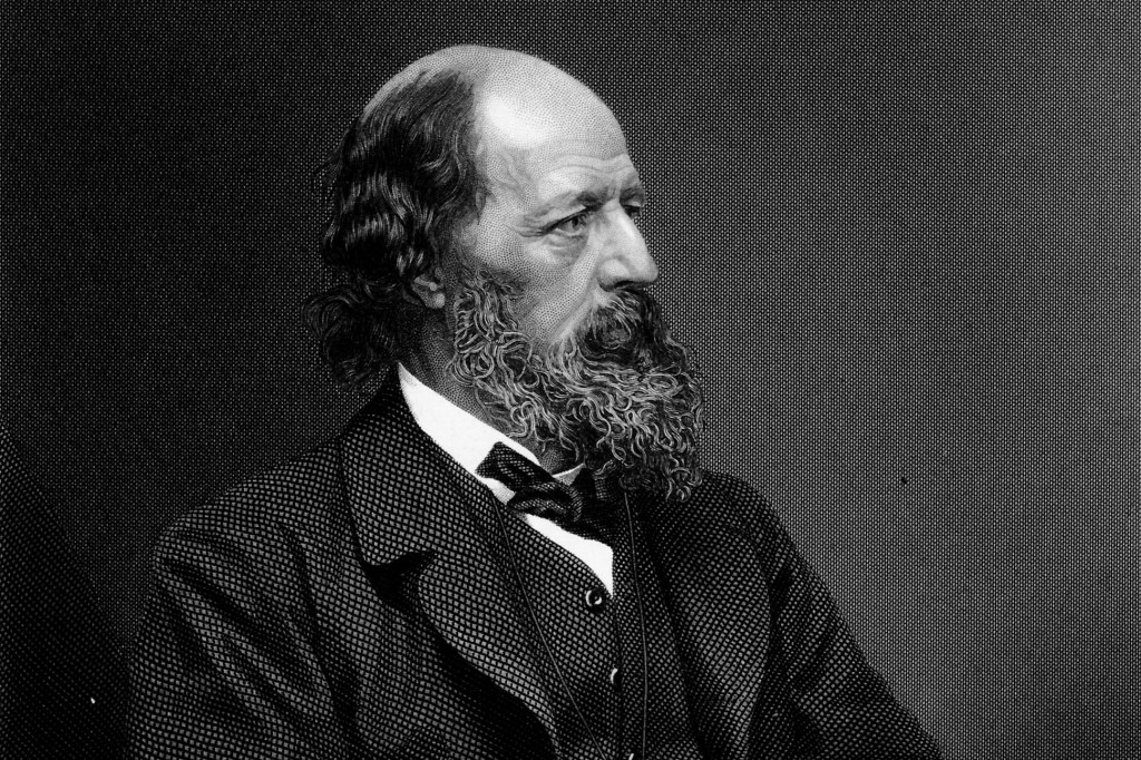 A black and white portrait of Lord Alfred Tennyson as a middle-aged bearded man in an elegant Victorian suit.